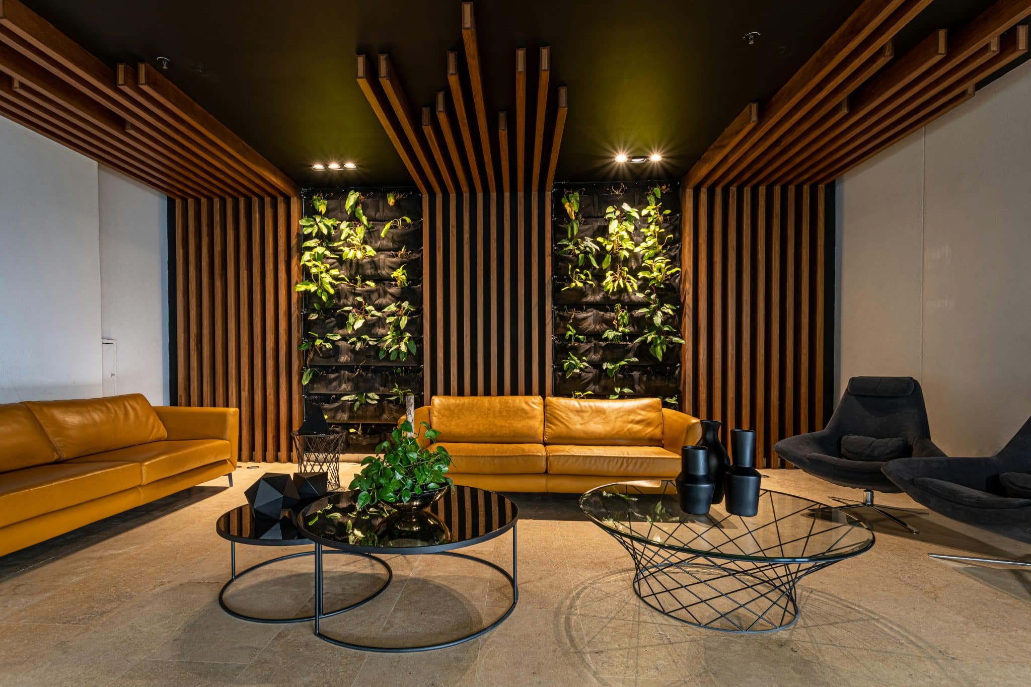Hospitality design: modern lobby with leather sofas, living wall, and wooden slats, building community beyond business.